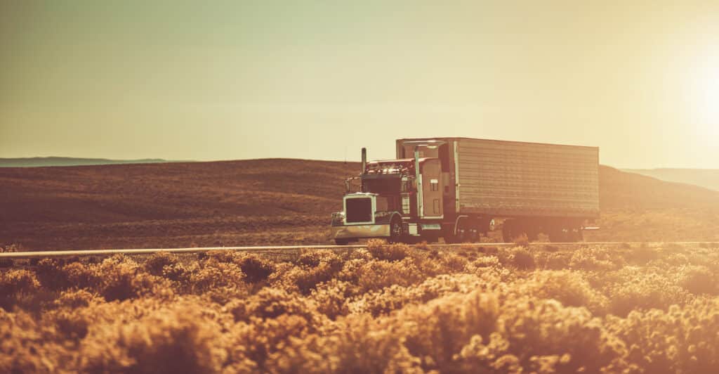 Semi Truck Crossing American West Wilderness. Cross Country Ground Shipping Theme.